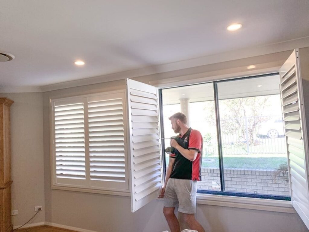 Phoenix Blinds staff member installing new plantation shutters in a home in Wollongong, Nsw