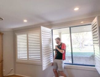 Phoenix Blinds staff member installing new plantation shutters in a home in Wollongong, Nsw